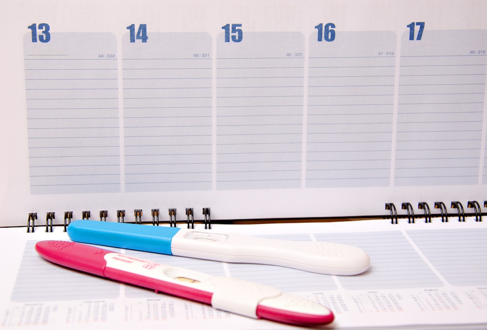 Pregnancy test over calendar